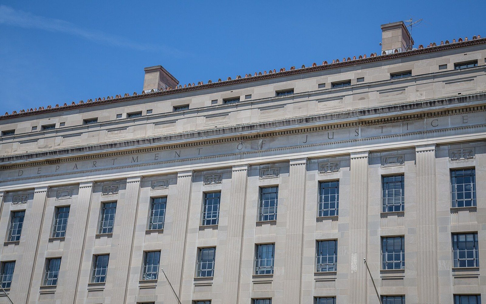 Upward view of the Department of Justice building's stone facade and rows of windows